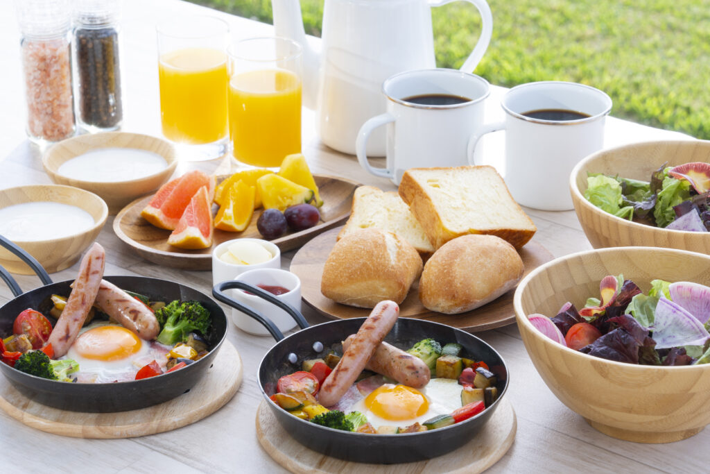 パンや、フルーツ、サラダなどテーブルいっぱいにある朝ごはん