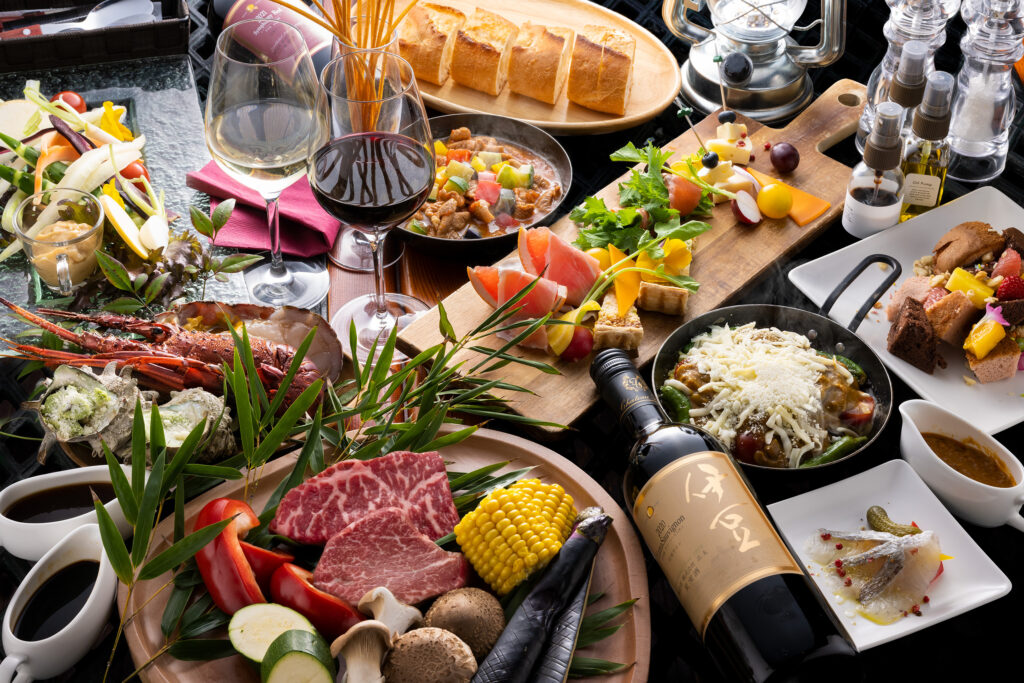 「中伊豆EAST WINDS VILLAGE」の豊富な肉、海鮮、野菜などの食材とワインが並んでいる